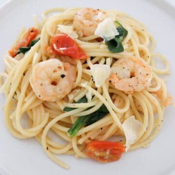 Prawn pasta with tomato and spinach on plate
